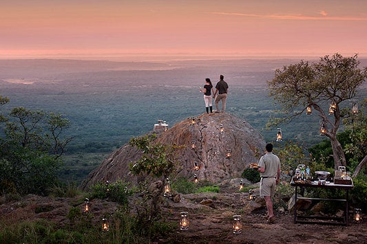 Couple standing on a viewpoint overlooking Phinda Private Game Reserve