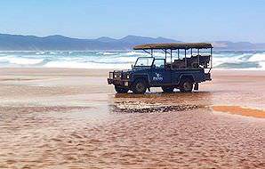 A safari vehicle parked on a beach along the wild shores that fringe Phinda.
